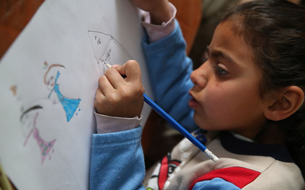 UNICEF-Report: Mädchen Amira beim Zeichnen in einer Flüchtlingsunterkunft