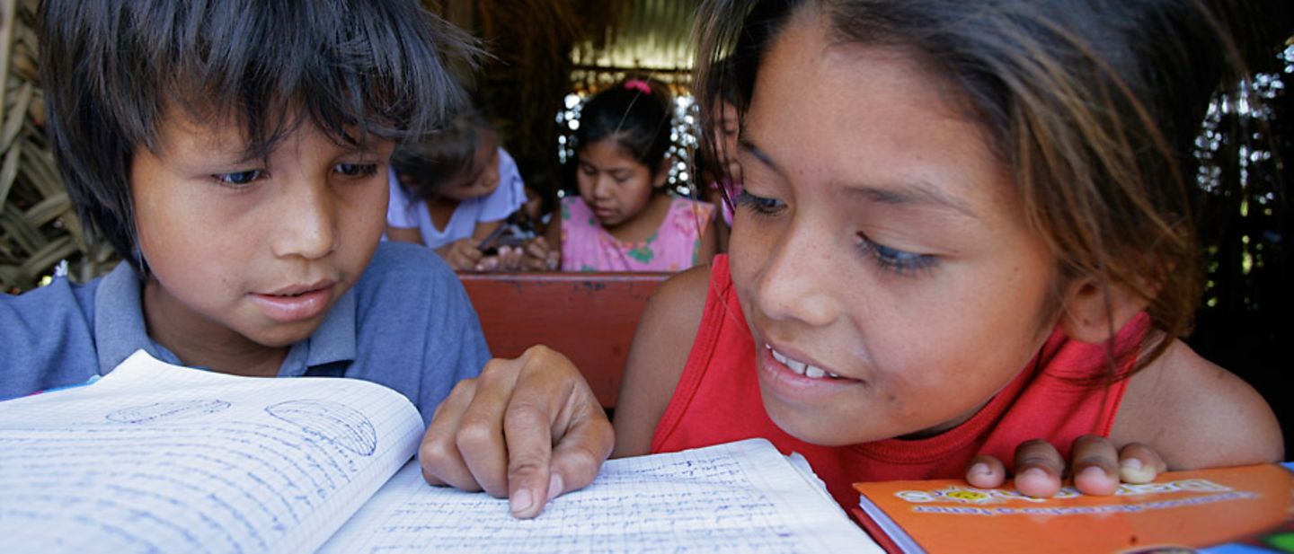 UNICEF in Bolivien: Ein Junge und ein Mädchen lesen zusammen.