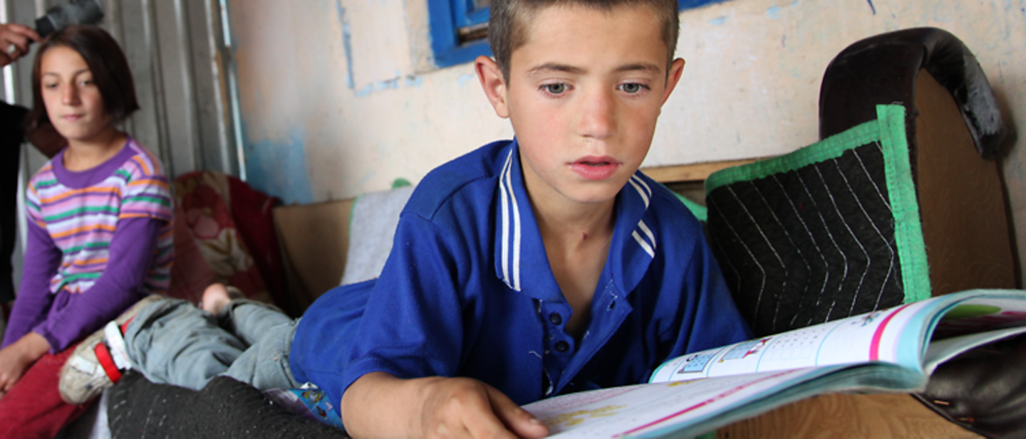 UNICEF im Kosovo: Ein Junge liest in einem Schulbuch.
