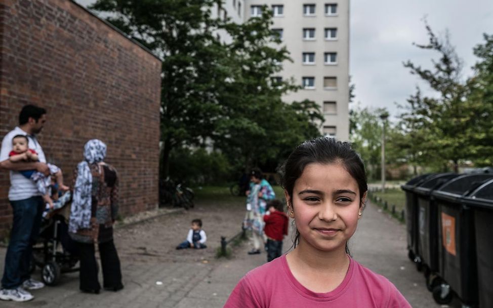 Ein Mädchen steht in einer Flüchtlingsunterkunft in Berlin - ein trostloser Ort für Kinder.
