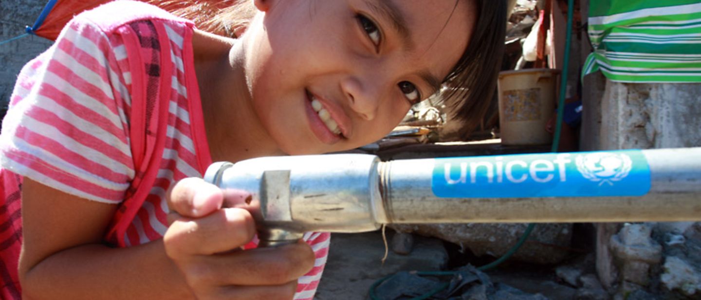 Trinkwasser: Das Mädchen zapft frisches Wasser