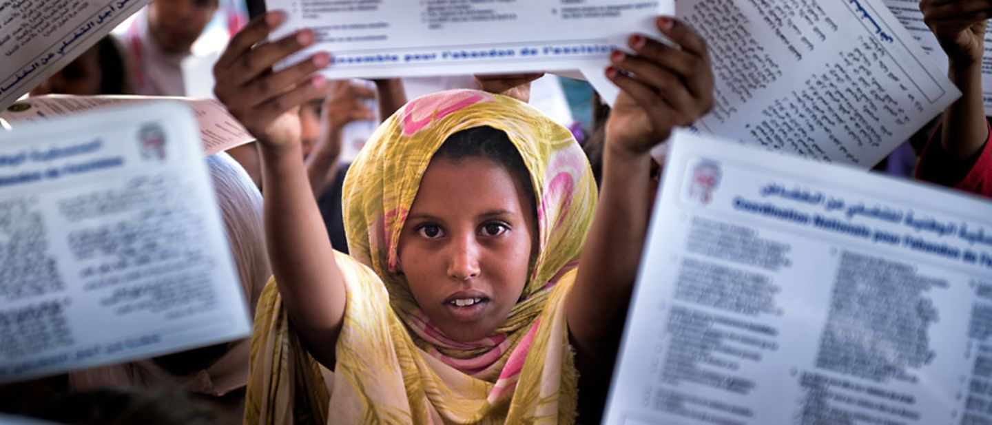 Genitalverstümmelung: Ein Mädchen hält ein Flugblatt hoch