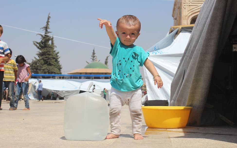 Syrien-Bürgerkrieg: Ein Mädchen in Aleppo erhält sauberes Wasser.