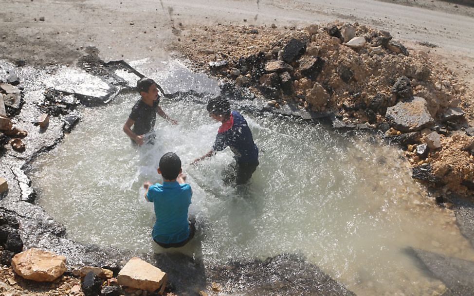 Aleppo: Kinder spielen im Wasser der zerstörten Leitung