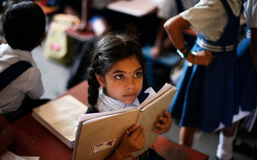 Indien: Ein Mädchen mit Schulbuch