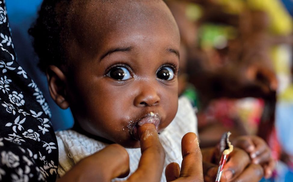 Nigeria: Ein Baby wird mit Erdnusspaste gefüttert