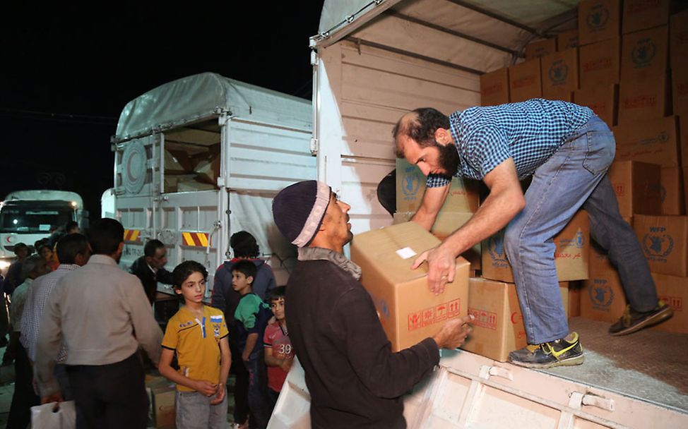 Hilfsgüter erreichen Syrien: Helfer entladen die lebensrettenden Lieferungen
