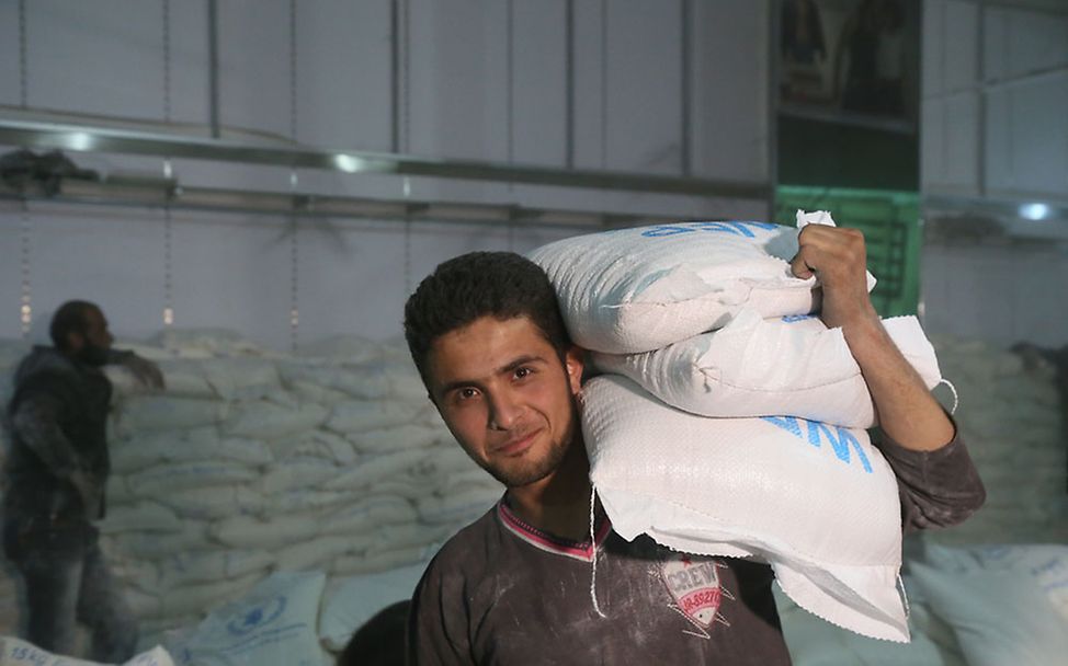 Hilfsgüter erreichen Syrien: Menschen vor Ort helfen, die Lieferungen zu verteilen