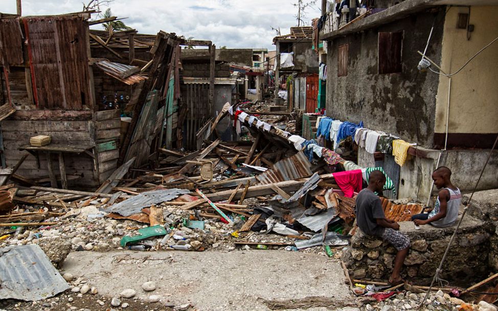 Hurrikan Matthew: Kinder in Haiti sitzen zwischen zerstörten Gebäuden.