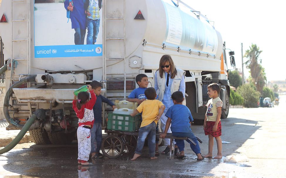 Nothilfe Syrien: UNICEF-Mitarbeiterin und Kinder am Trinkwasser-LKW