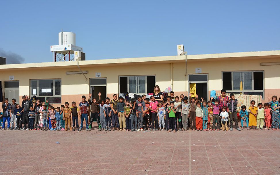 Irakreise: Eva Padberg mit Kindern vor einem ehemaligen Schulgebäude