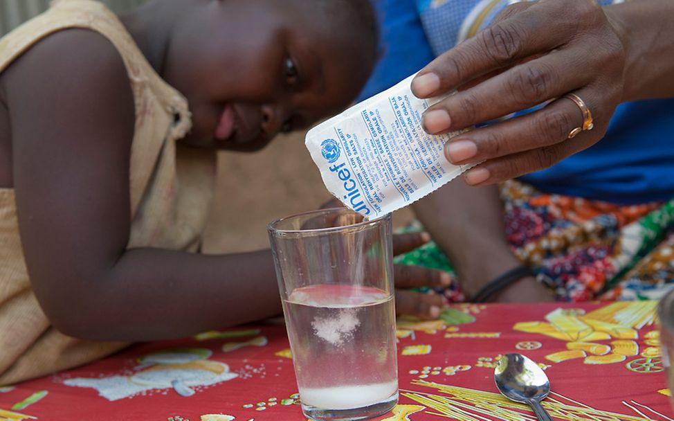 Die drei Jahre alte Majoue aus Chad bekommt eine spezielle Trinklösung aus Glucose, Kochsalz und Elektrolyten gegen Durchfall.
