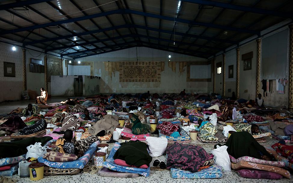 Flüchtlinge liegen in einem ehemaligen Jugendgefängnis auf Matratzen.