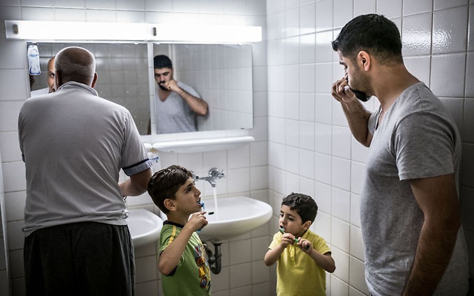 UNICEF-Studie Flüchtlingskinder: Syrische Familie beim Zähneputzen im gemeinschaftlich genutzten Waschraum