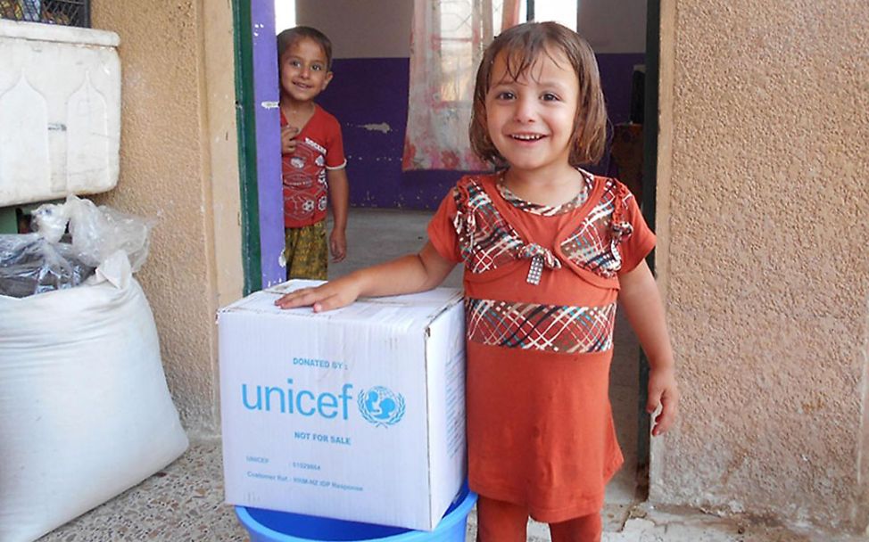 Irak: Ein Mädchen freut sich über ein UNICEF-Paket