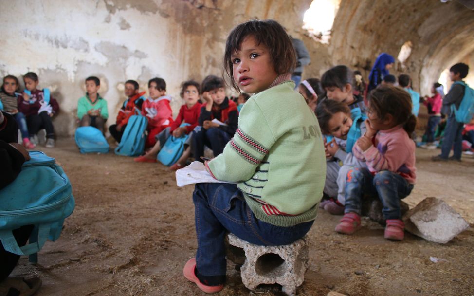 In Dar'a (Syrien) lernen Kinder in einem notdürftig zur Schule umgerüsteten Gebäude.