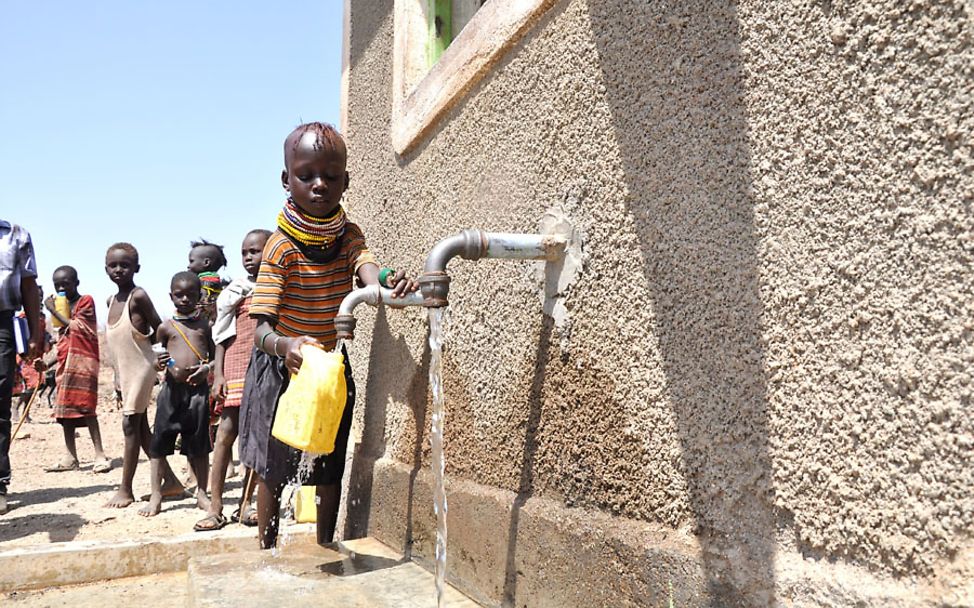 Dürre in Kenia: Ein Kind holt Wasser an einer reparierten Wasserstelle
