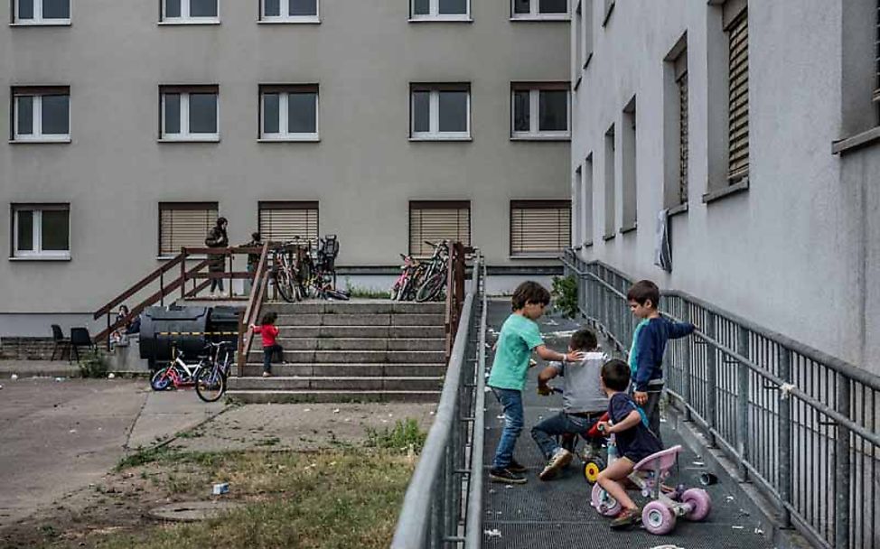 Kinder spielen vor einem Flüchtlingsheim 