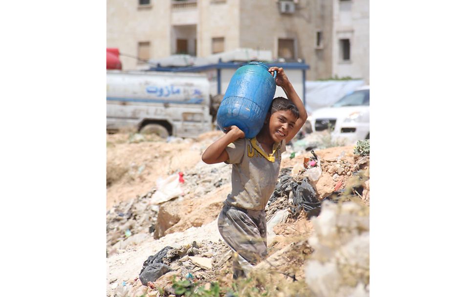 Aleppo: Ein Junge transportiert einen Wasserkanister