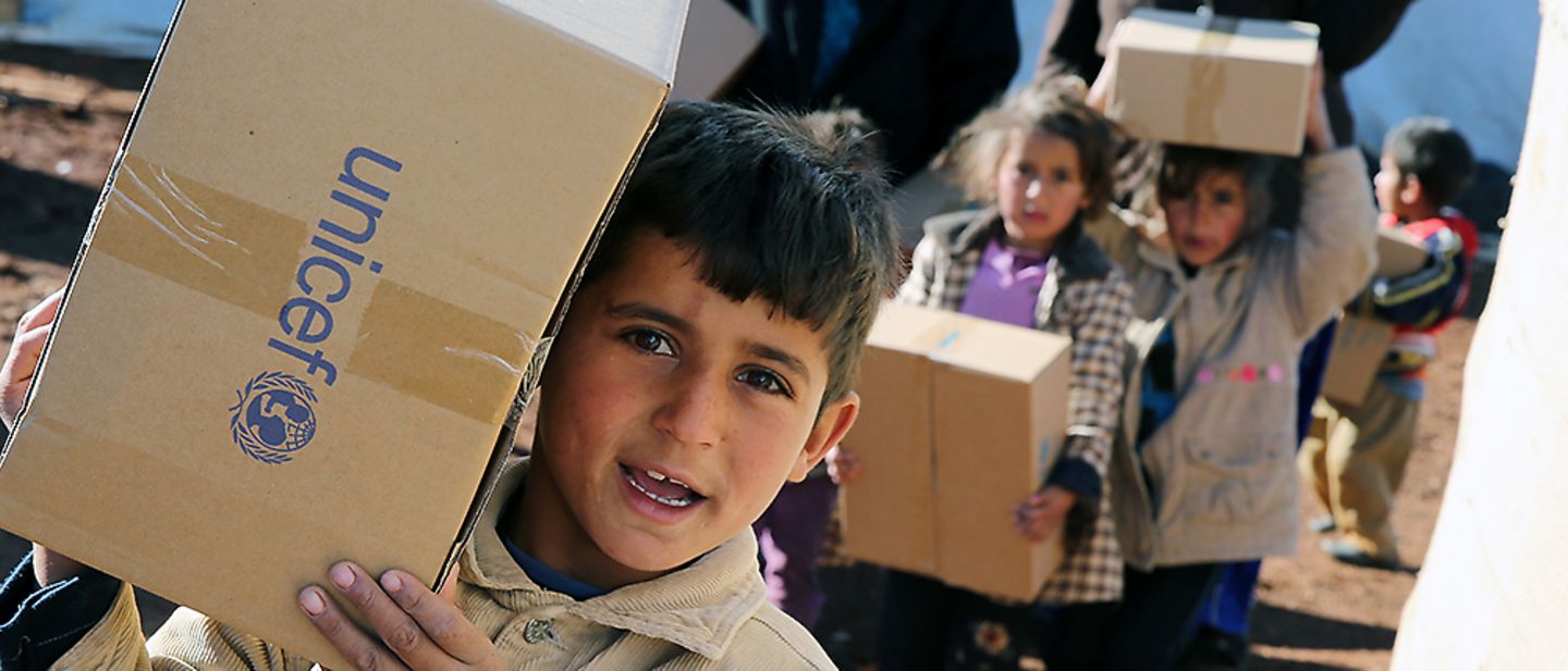 Der Weg der Spende: Junge trägt UNICEF-Kiste