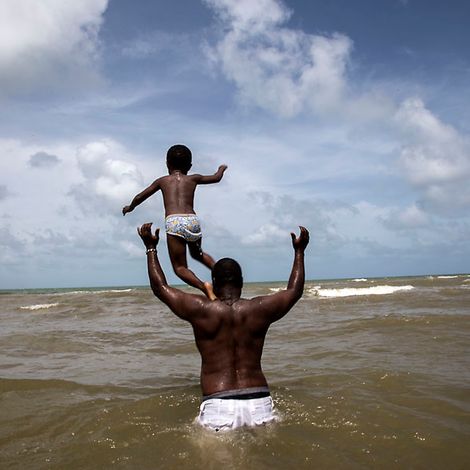 Ein Vater spielt mit seinem Sohn im Meer