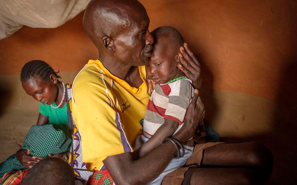 Uganda: Ein Vater hält seinen Sohn liebevoll in seinem Arm