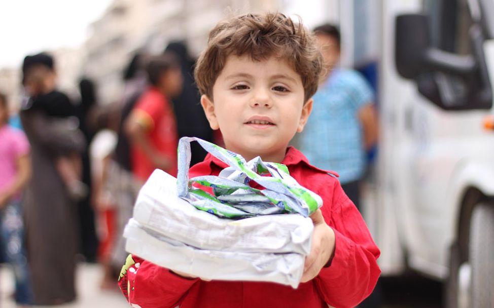 Syrien-Krieg: Junge mit Hilfsgütern aus der mobilen Klinik