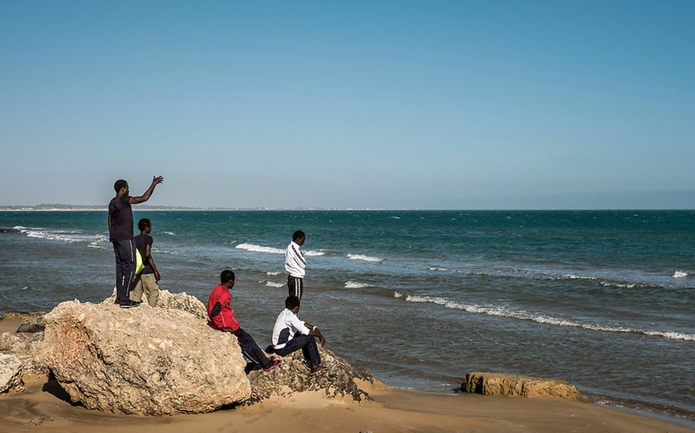Geflüchtete und migrierte Jugendliche in Italien blicken auf das Meer.