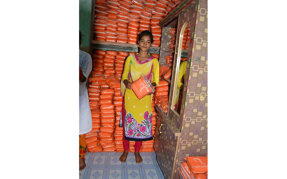 Bangladesch: Ayshwa steht im Lagerraum mit einer Packung Binden