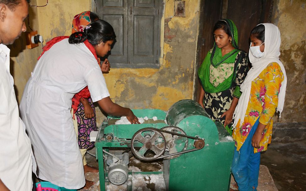 Bangladesch: Eine Maschine verfranst die Baumwolle, damit sie aufnahmefähiger ist.