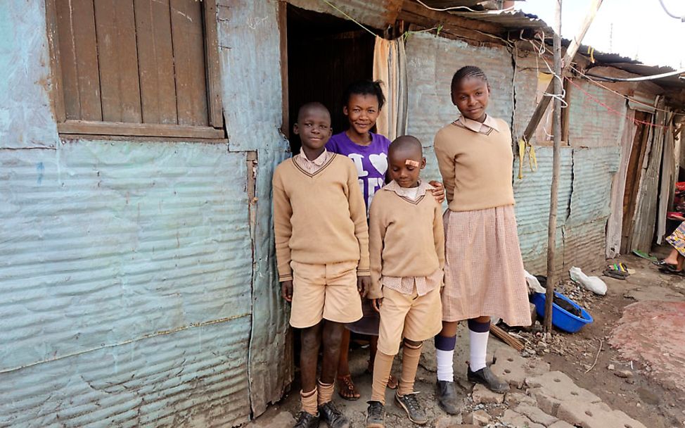 Kenia: Judith Achieng mit ihren drei Kindern vor ihrer Wohnung
