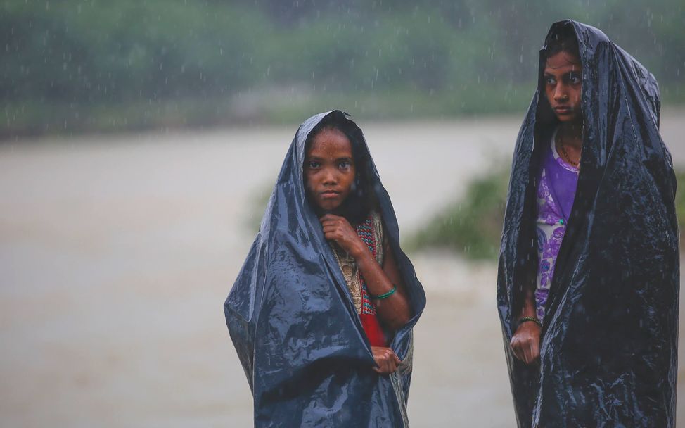Monsun in Asien: Mädchen aus Nepal im heftigen Monsunregen