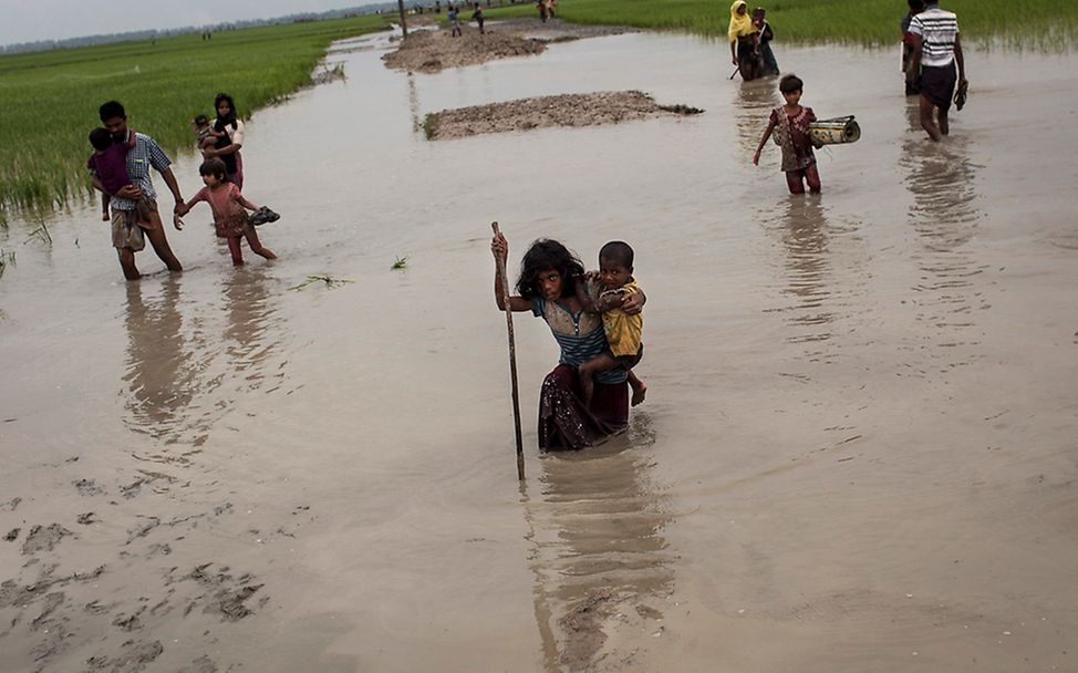 Rohingya: Ein kleines Mädchen trägt ihren Bruder durch den Schlamm
