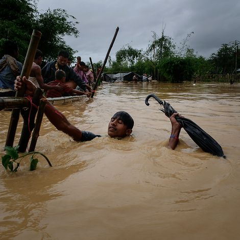 Rohingya: Ein Junge versucht sich aus den Fluten zu retten