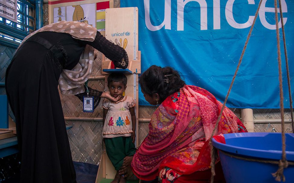 UNICEF-Helfer messen die Köpergröße eines Rohnigya-Mädchens