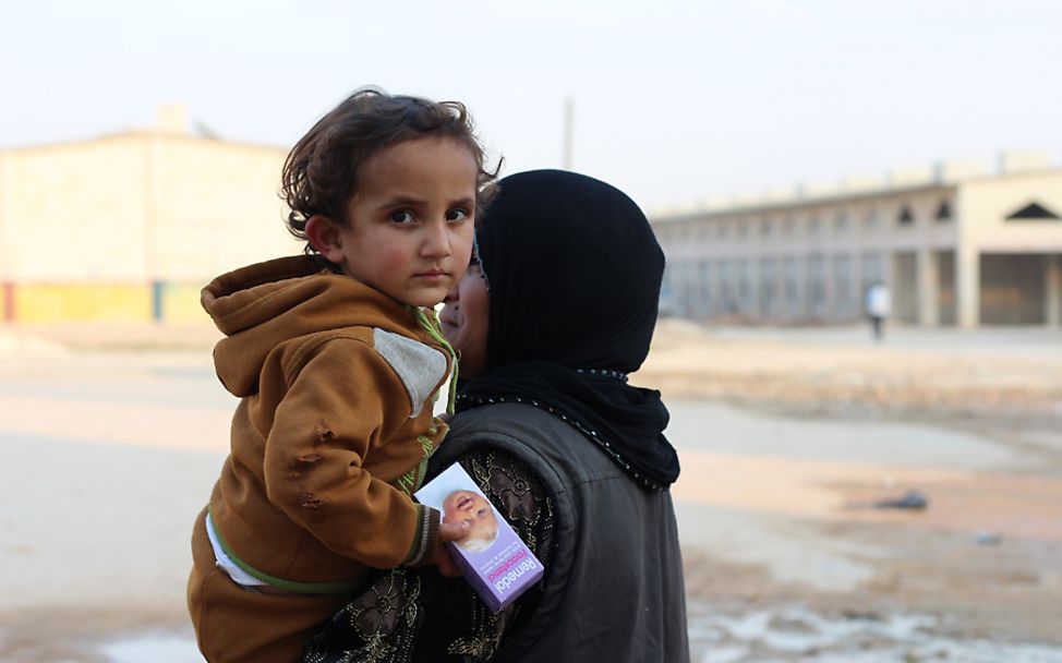 Syrien: Ein kleines Kind wird in Jibreen von ihrer Mutter getragen
