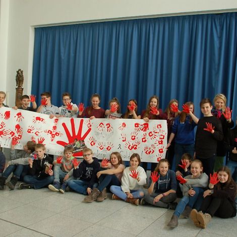 red hands banner Mariengymnasium