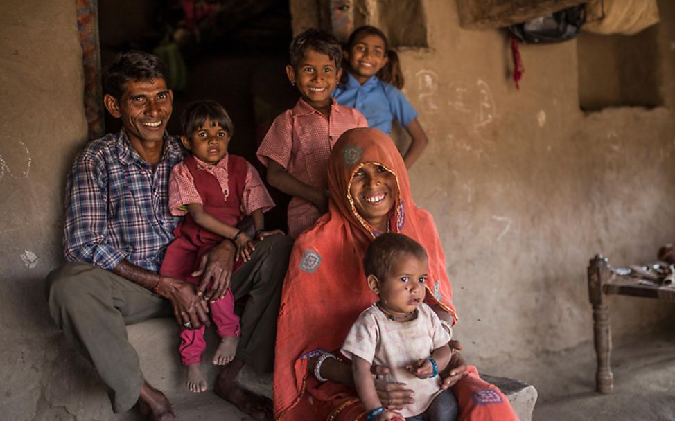 Indische Familie sitzt vor ihrem Haus