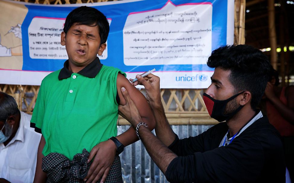 Bangladesch: Ein Kind wird von einem UNICEF-Mitarbeiter geimpft