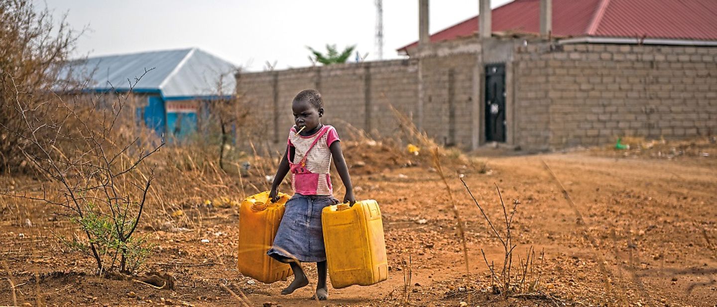 Ein Kind mit seinen Kanistern auf den Weg zur nächsten Wasserquelle