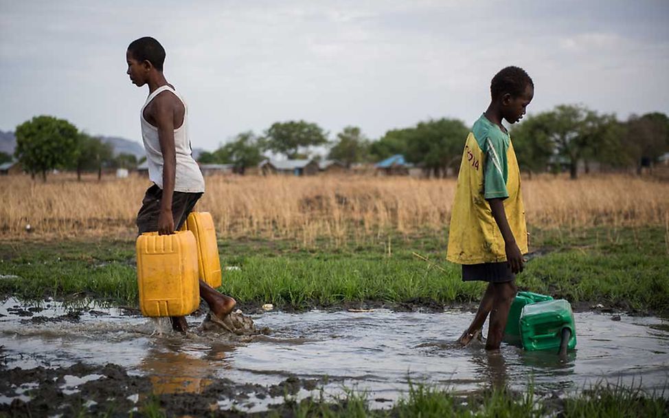 Mutakel, 16, und Joseph, 12, holen Wasser aus einer kaputten Leitung. | © UNICEF/Hatcher-Moore  