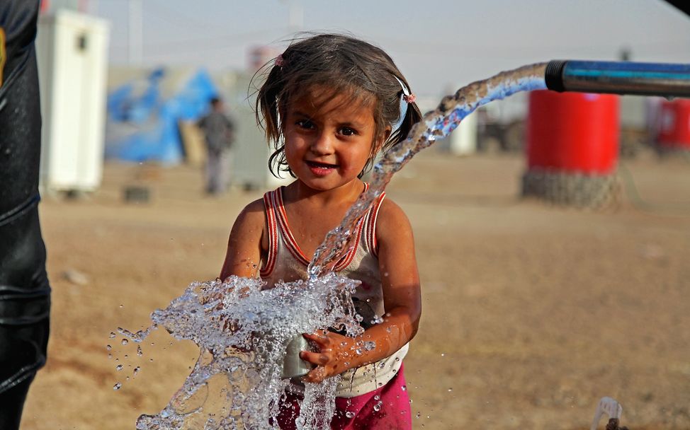 Irak: Ein Flüchtlingsmädchen freut sich über Trinkwasser