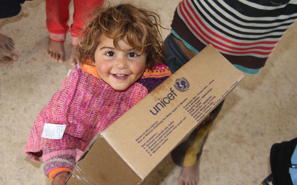 Jordanien: Ein Kind freut sich über ein UNICEF-Hilfspaket
