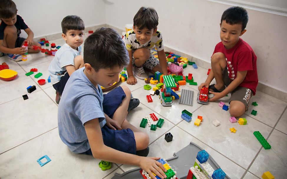 Kinder spielen im Zentrum für Geflüchtete in Athen mit Bausteinen.