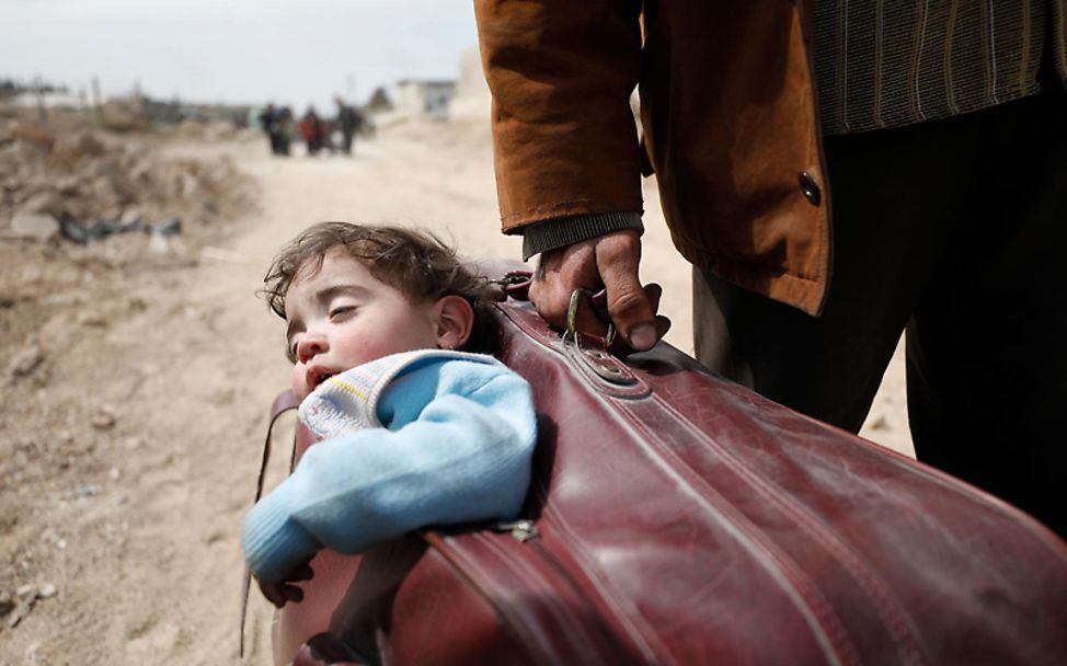 Syrien: Ein schlafendes Kind wird in einem Koffer getragen