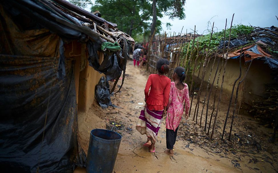 Rohingya-Bangladesch: Yasmin und ihre Freundin laufen durch das matschige Flüchtlingslager.