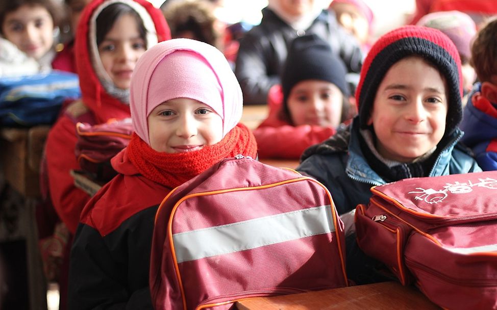 Schutz für Kinder in Schulen: Lächelnde Kinder in einer Schule in Syrien