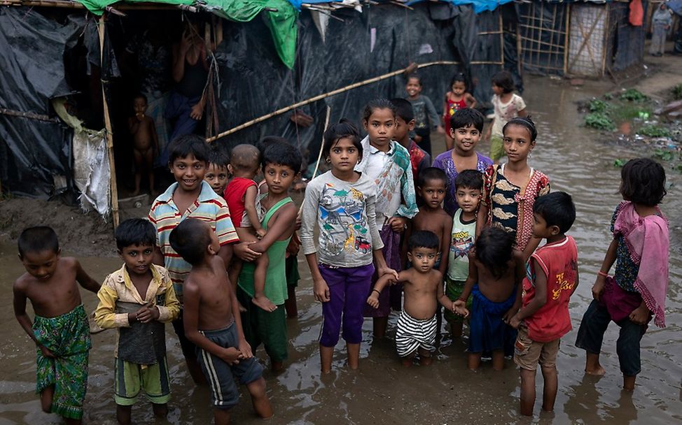 Rohingya Flüchtlingskinder stehen im Wasser.