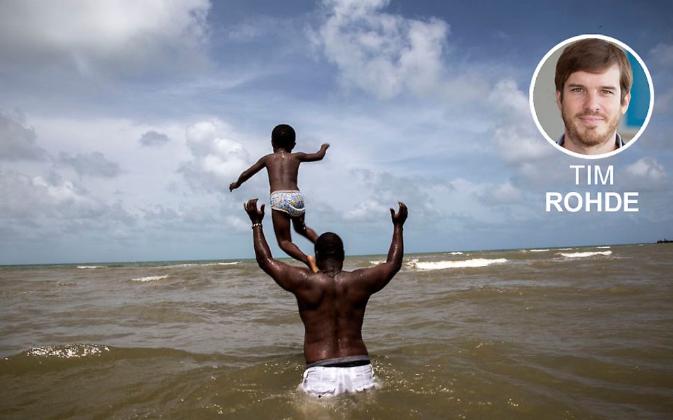 Ein Vater spielt mit seinem Sohn im Meer