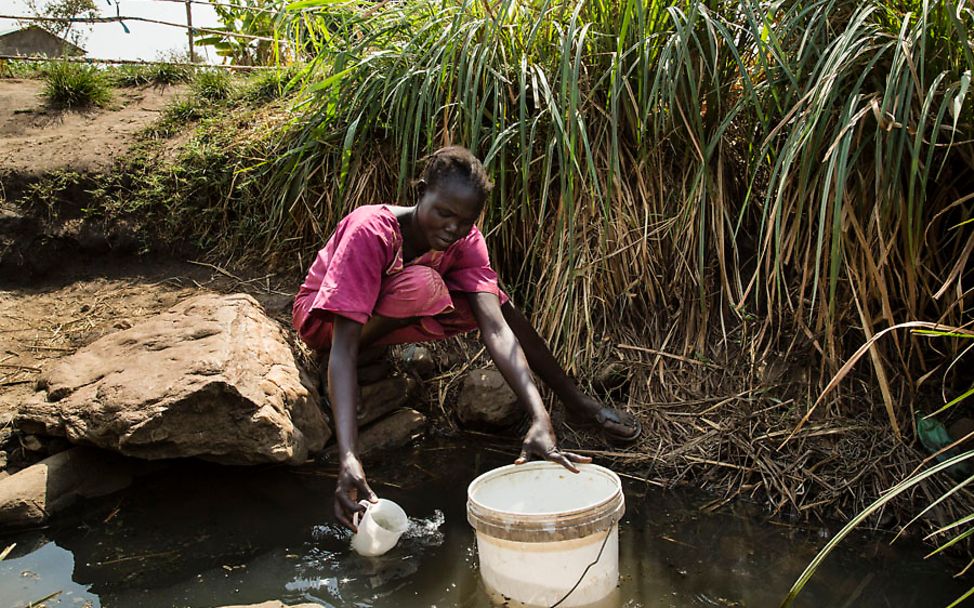 Barakas Mutter holt verschmutztes Wasser aus einem Fluss.